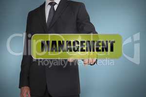 Businessman touching the word management written on green tag