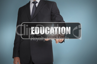 Businessman touching the word education written on black tag