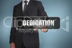 Businessman touching the word dedication written on black tag