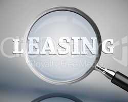 Magnifying glass showing leasing word in white