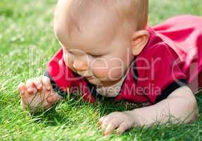 baby girl playing on green grass