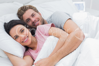 Couple embracing in bed