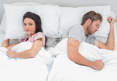 Woman looking at camera while her husband is sleeping