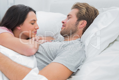 Attractive couple awaking and looking at each other