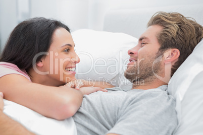 Cheerful couple awaking and looking at each other
