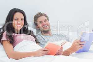 Cheerful couple holding books