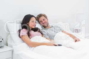 Couple in bed watching TV