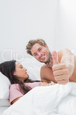 Man giving thumb up next to his sleeping partner