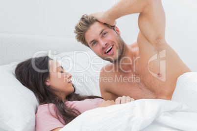 Shirtless man posing next to his sleeping partner