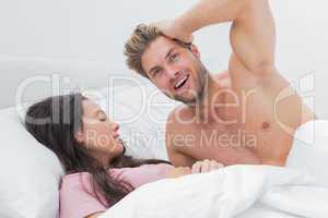 Shirtless man posing next to his sleeping partner