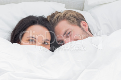 Couple hiding under the duvet