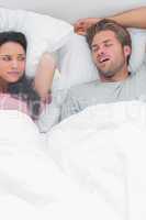Brunette annoyed by the snoring of her husband