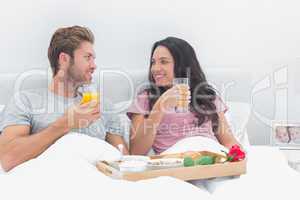 Beautiful couple having breakfast in bed