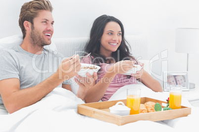 Beautiful couple eating cereal for breakfast