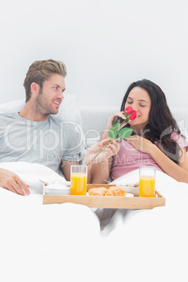 Woman smelling a rose given by her husband