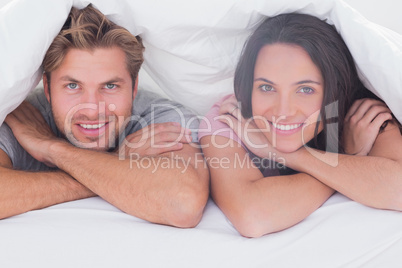 Couple smiling under the duvet