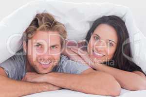 Beautiful couple smiling under the cover