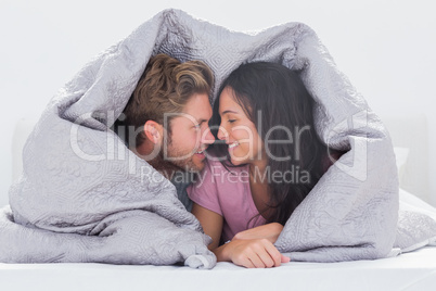 Attractive couple wrapped in the duvet