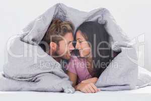Attractive couple wrapped in the duvet