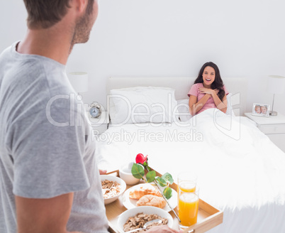 Man bringing breakfast to his impressed wife
