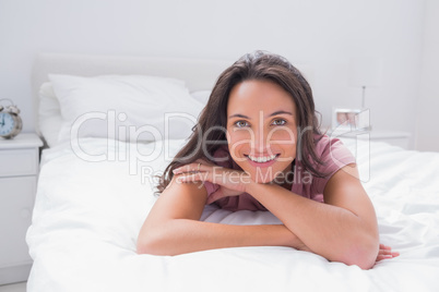 Cheerful woman lying on bed