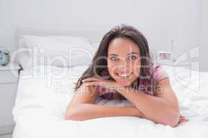 Cheerful woman lying on bed