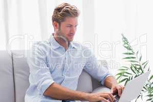 Man using a laptop on the couch in the living room