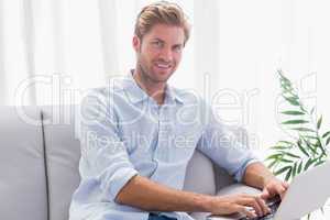 Man using his laptop sat on the couch