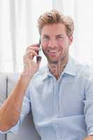 Man smiling while he is having a phone conversation