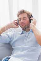 Man relaxing while listening to music on a couch