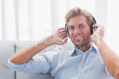 Man listening to music with headphones in the living room