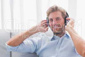 Man listening to music with headphones in the living room
