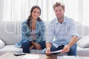 Couple doing their accounts sat in a couch