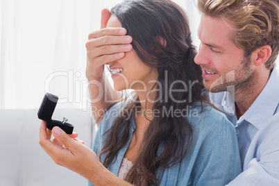 Man hiding his wifes eyes to offer her an engagement ring