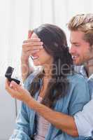 Man hiding wifes eyes to offer her an engagement ring