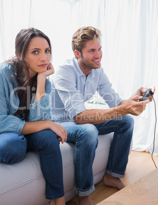 Sad woman annoyed that her partner is playing video games