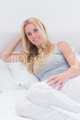 Blonde woman lying on bed