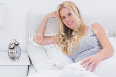 Blonde woman lying on her bed