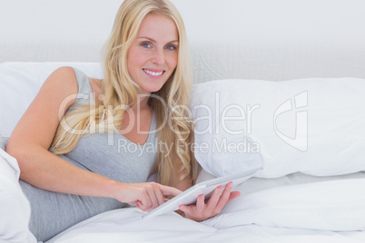 Woman using a tablet in bed