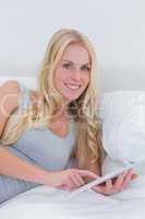Woman touching her tablet in bed