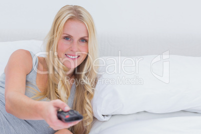 Woman pointing remote control at the camera