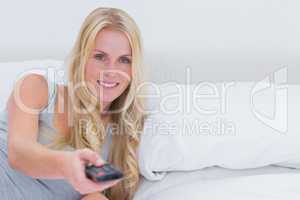 Woman pointing remote control at the camera