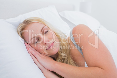 Blonde woman sleeping in her bed