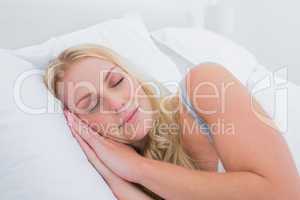 Blonde woman sleeping in her bed