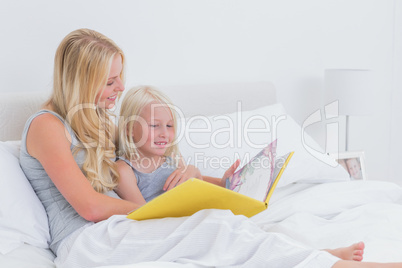 Blonde mother reading a story to her daughter