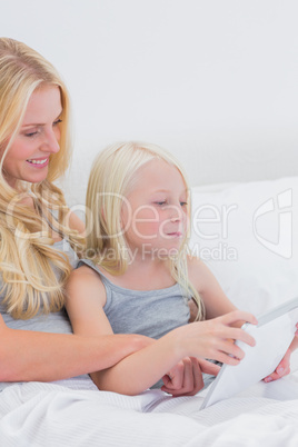 Happy mother and daughter using a tablet