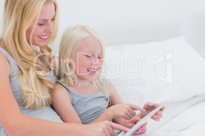 Cheerful mother and daughter using a tablet