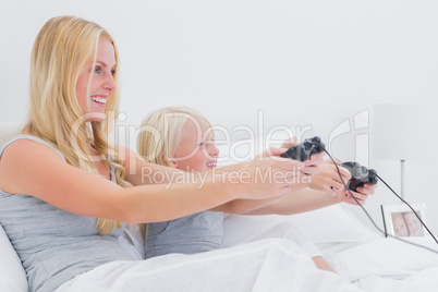 Mother and daughter having fun playing video games