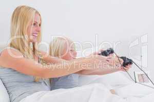 Mother and daughter having fun playing video games