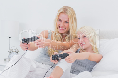 Cheerful mother and daughter playing video games Cheerful mother and daughter playing video games